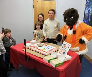 Jeff Knapp, and his family, one of the party sponsors cuts the birthday cake with Skokie as a highlight of the night.